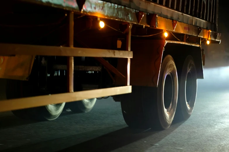 a truck driving down the road with its lights on