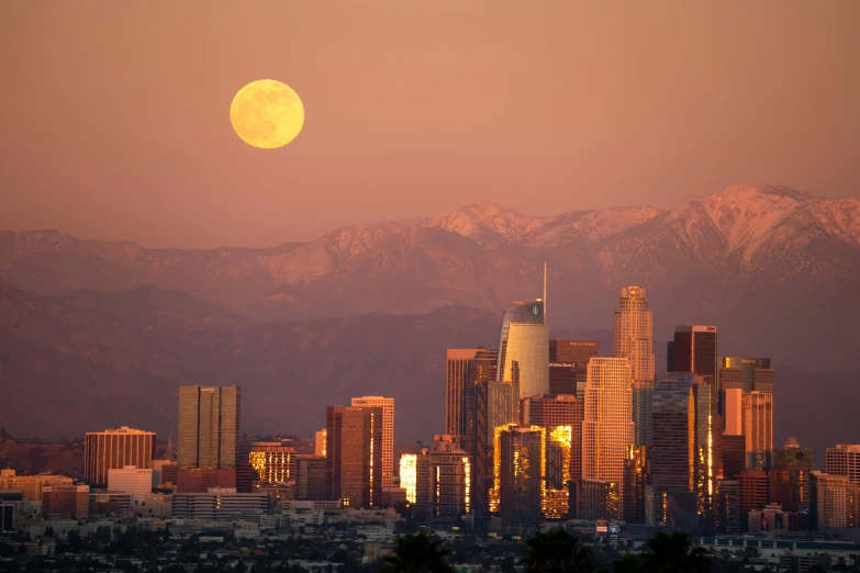 a moon is seen in front of a city skyline