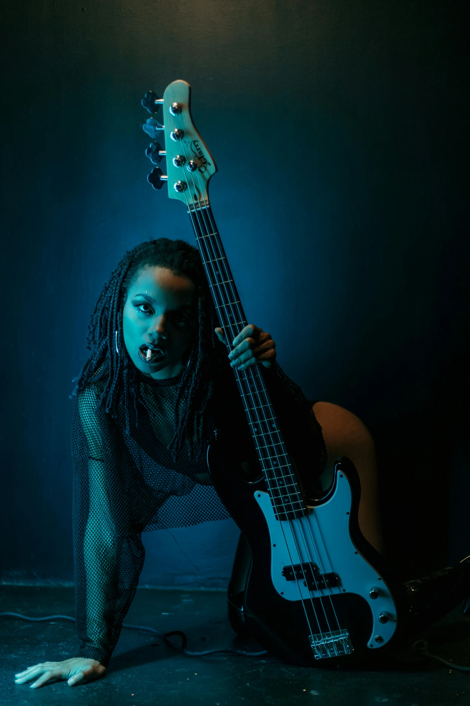 young african american woman posing for the camera with an electric bass guitar