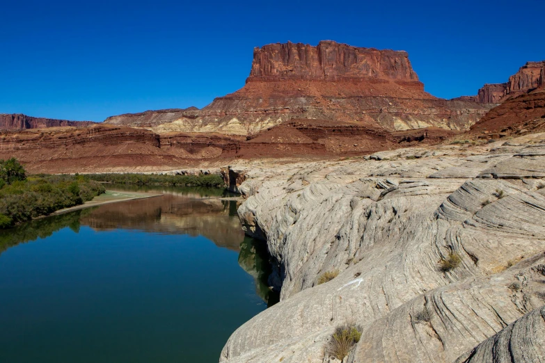 a blue pond is in the middle of a large canyon