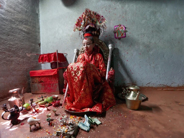 a person sitting on a chair surrounded by trash