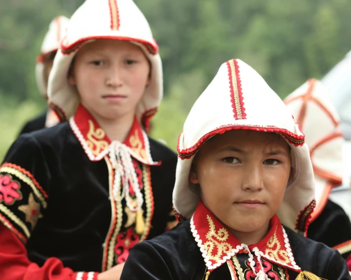 two little boys in folk costumes on an outdoor setting