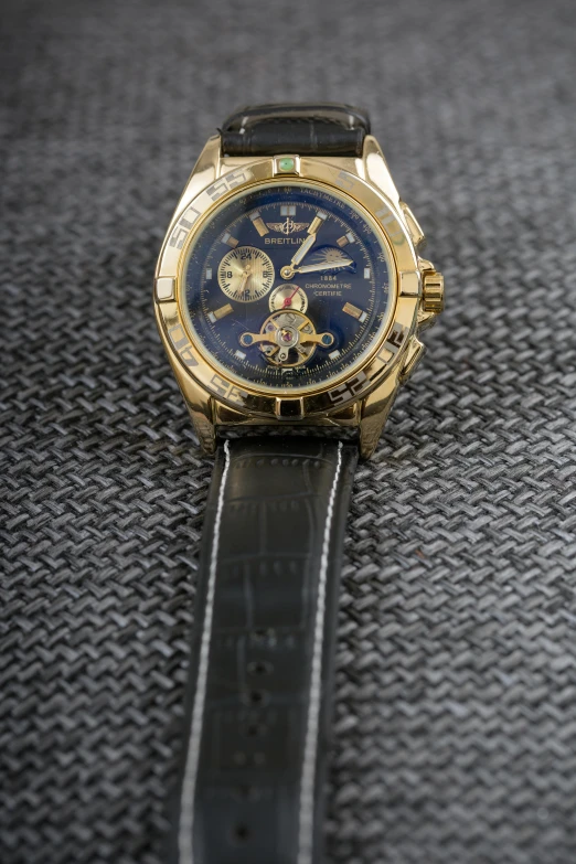 a gold and blue watch with a black strap