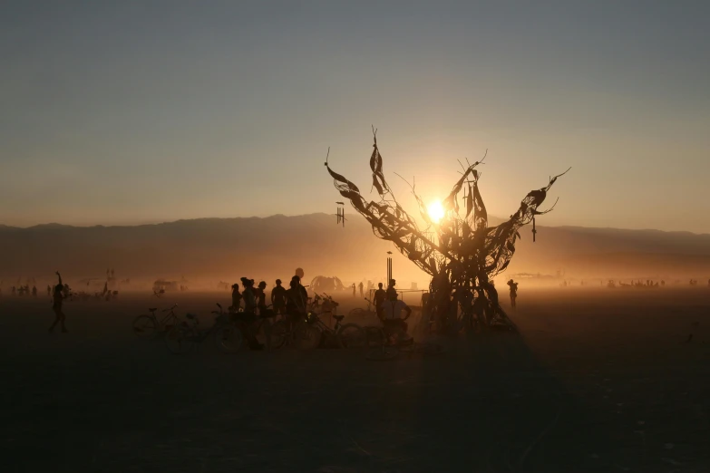 a group of people in the desert under a sun