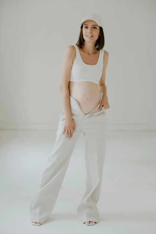 a pregnant woman with her belly tucked in her pants