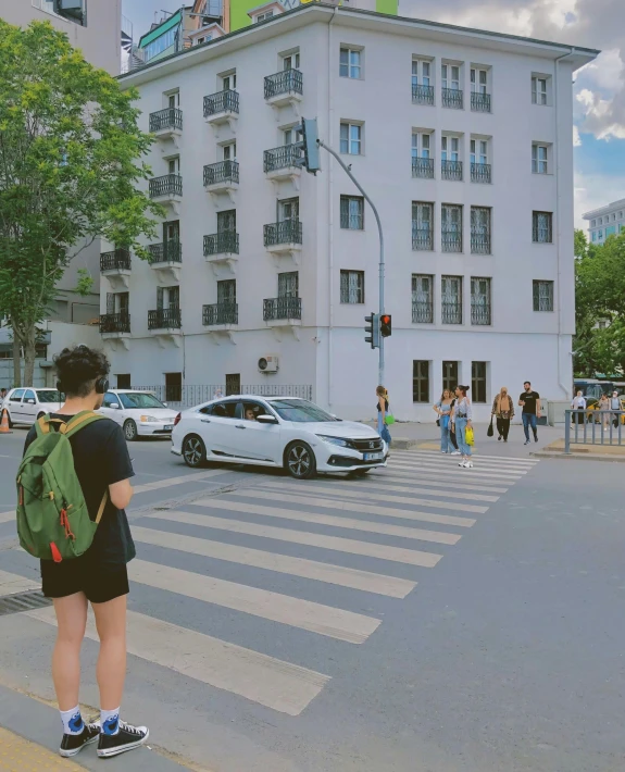 a person in a black dress standing on a cross walk