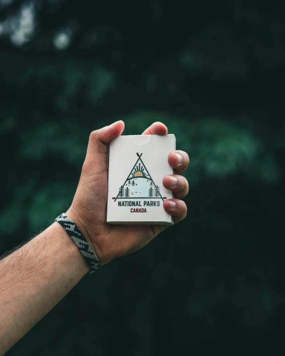 a hand holding out a small box with national park colorado written on it