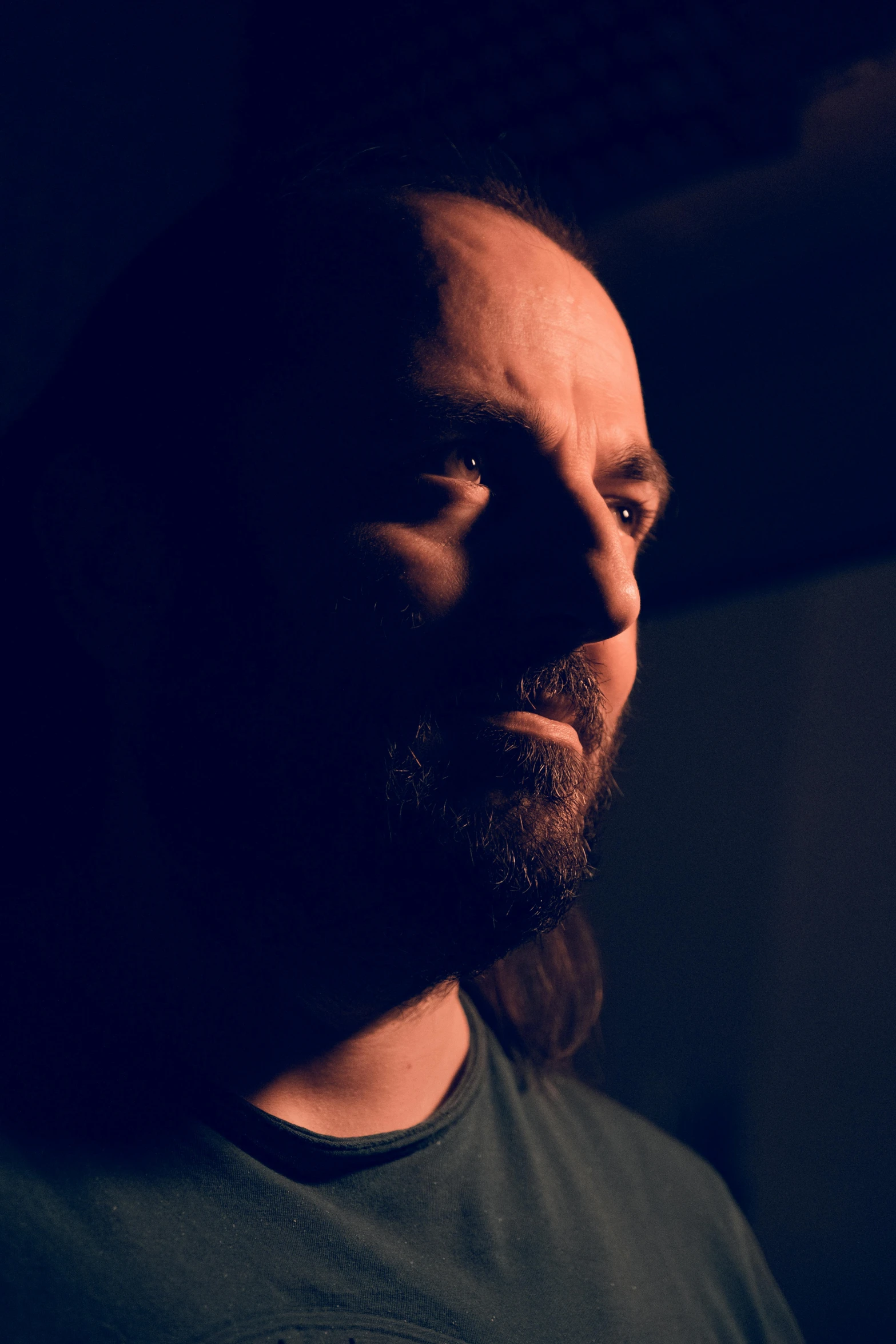 man with long beard and black shirt looking up