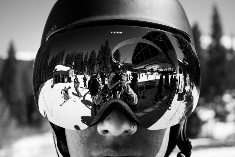 a reflection of people on skis in their ski goggles