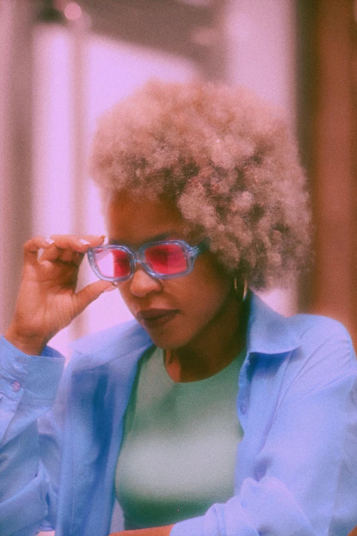 a woman sitting at a desk with glasses on