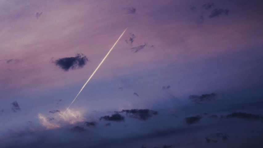 an airplane in the sky with clouds at night