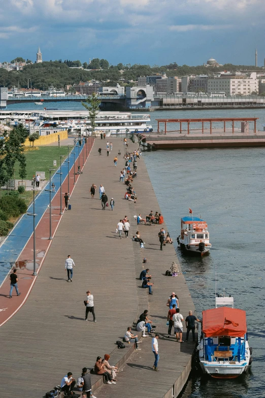 a group of people walking near water on a pier