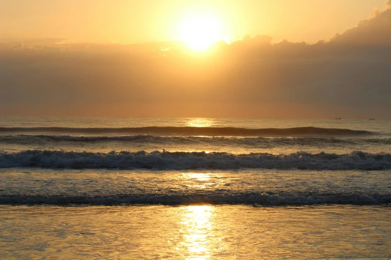 the sun shining over the ocean and making its way into the waves