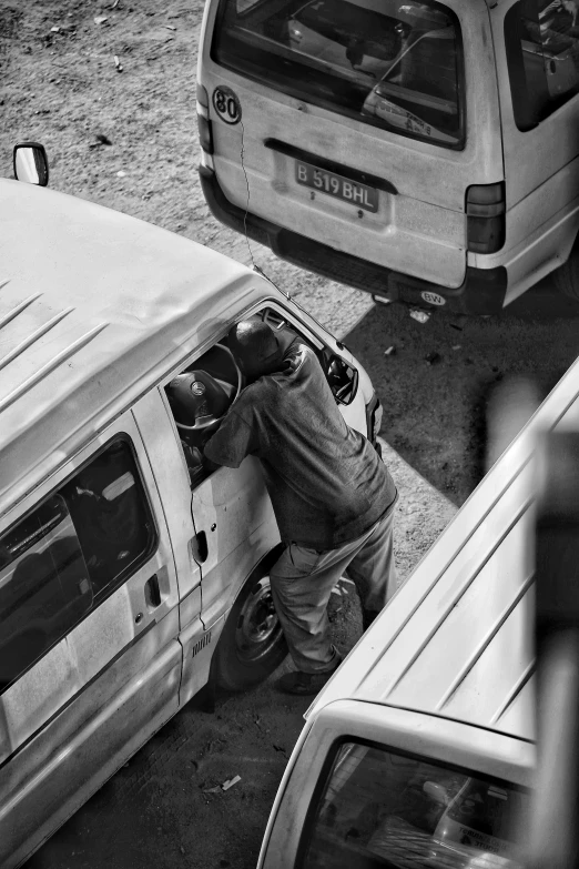 a person standing in the door of a van by an suv