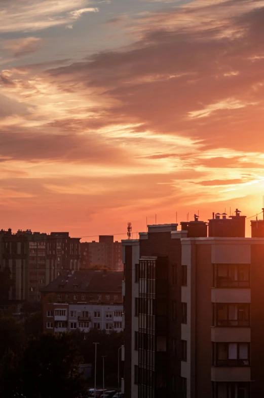 a sunset over a large building near a river