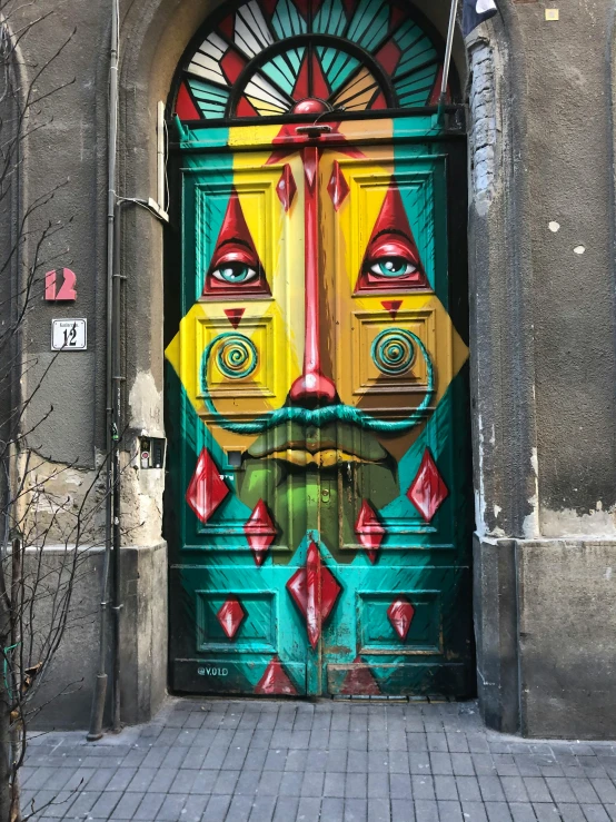 colorful door on side of building with face painted in green and yellow