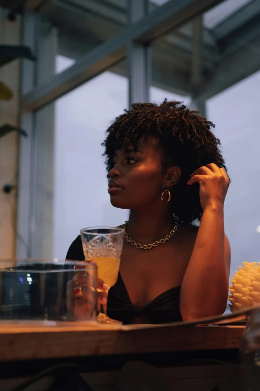 a beautiful woman sitting at a table with a glass