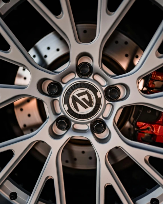 the front wheel of a car with chrome spokes and emblem