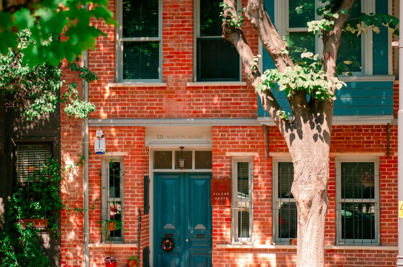 the front of a red brick house with blue doors