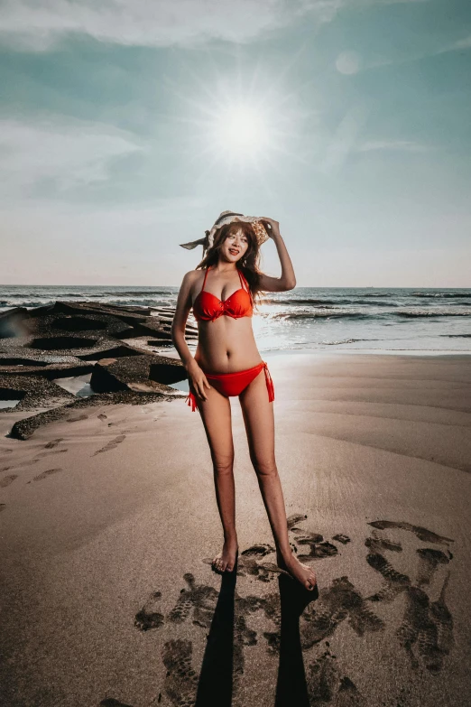 a woman in a bikini standing in the sand