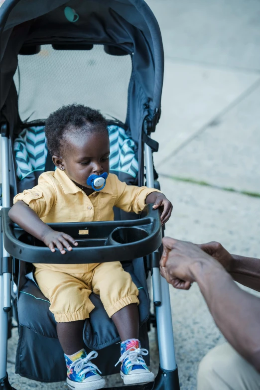 an infant is in the stroller playing with his pacifier