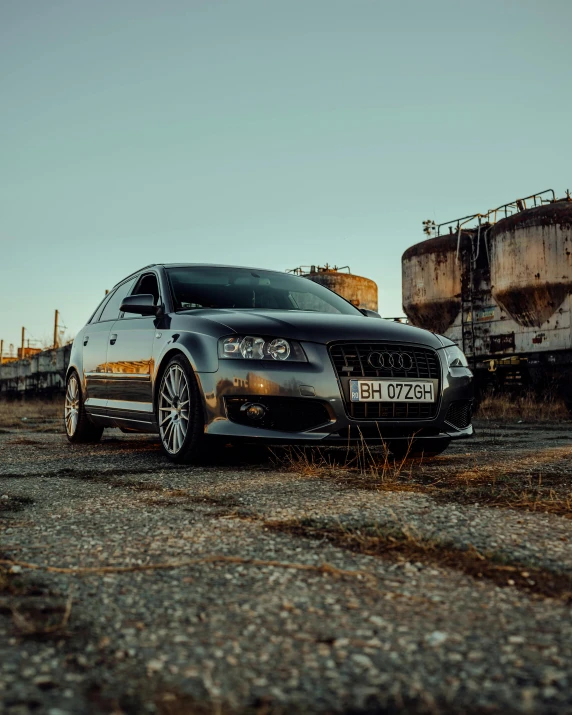 a gray suv sits near some grain silo