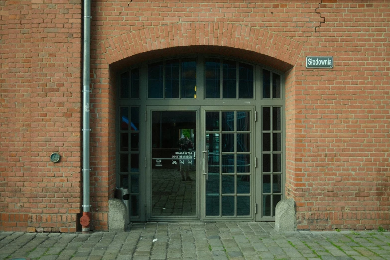 a large red brick wall with a big arch