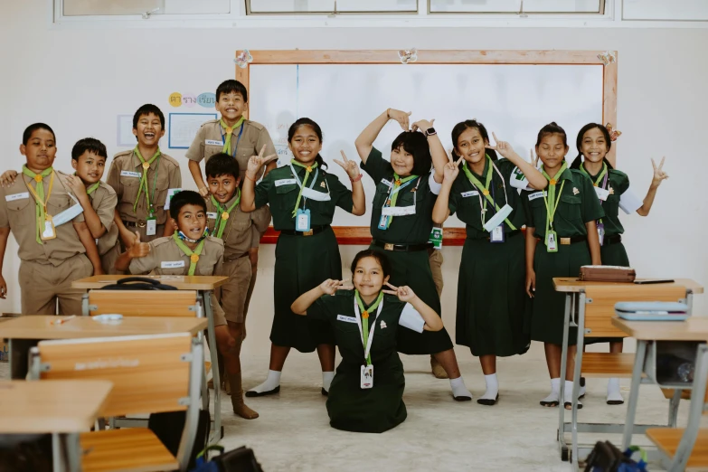 a schoolchild class posing for a po in front of their desks