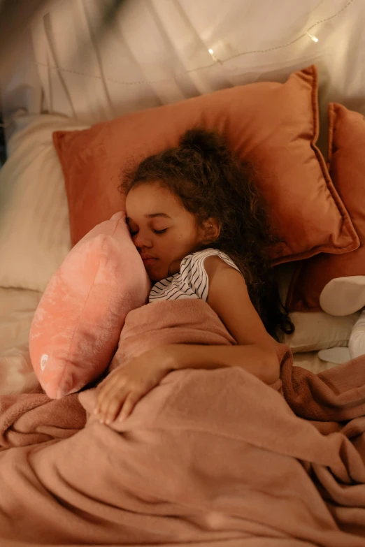 a little girl sleeps in her bed with pillows