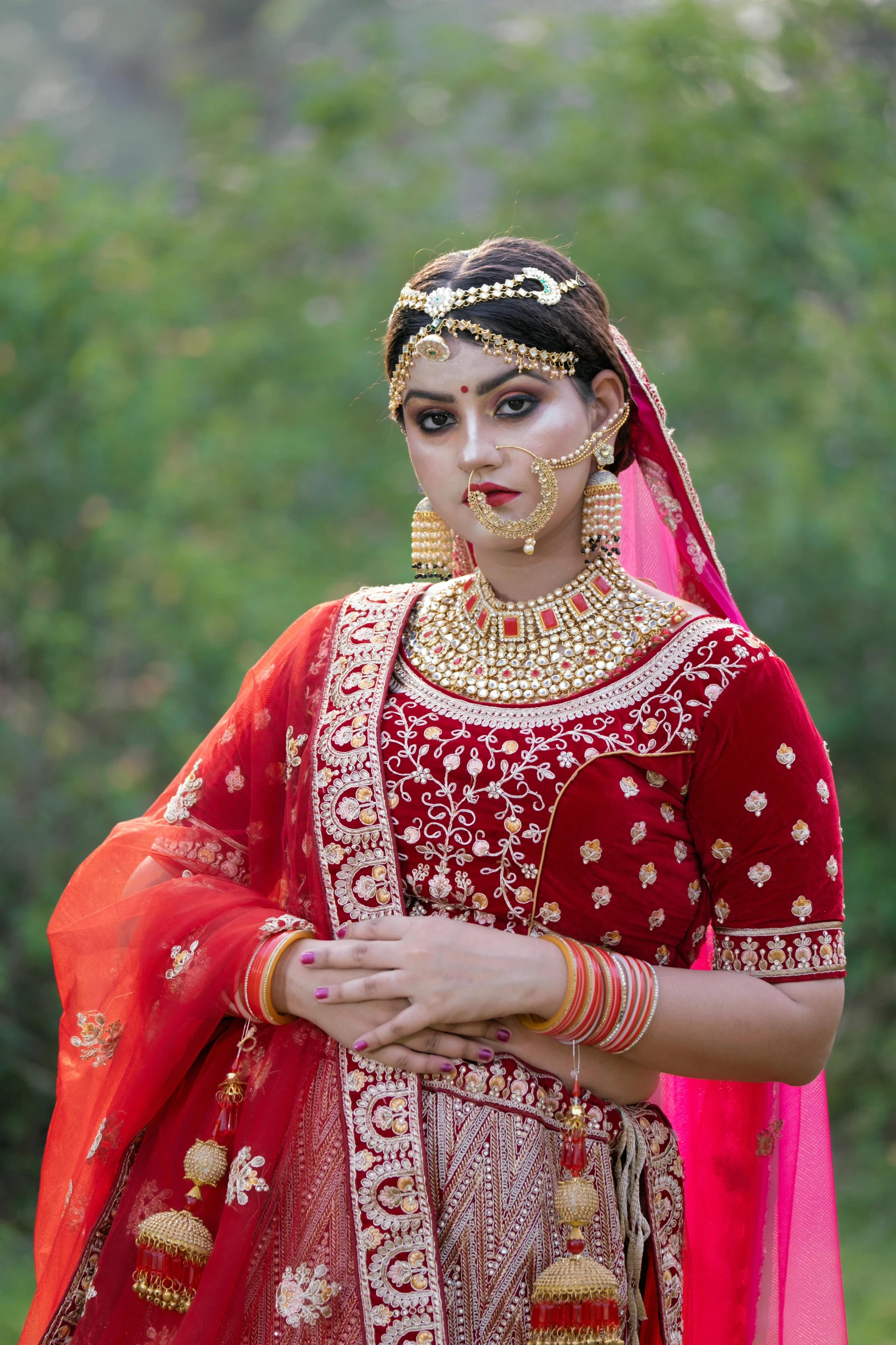 an indian bride in red and gold makeup is seen