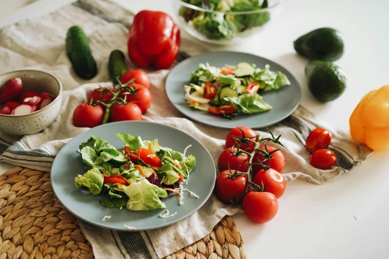 three blue plates of fresh salads sit on a table