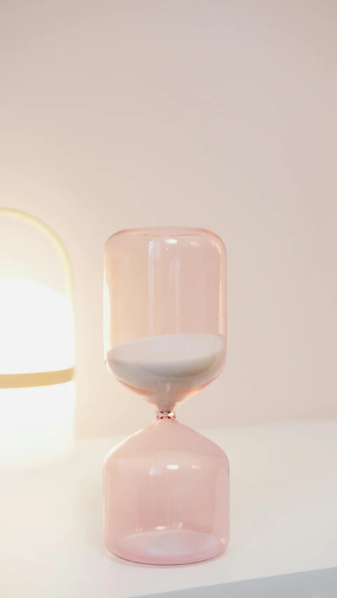 a glass with an hour in it sitting on a shelf