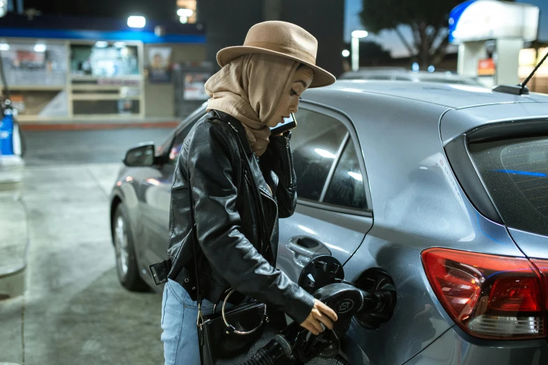 woman in a hoodie putting her hand inside a car