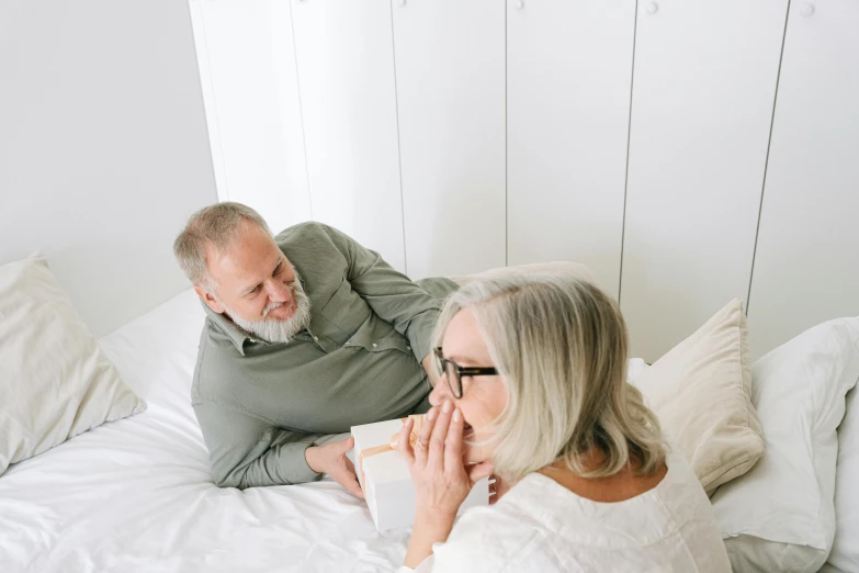 a woman on her bed with an older man on the bed