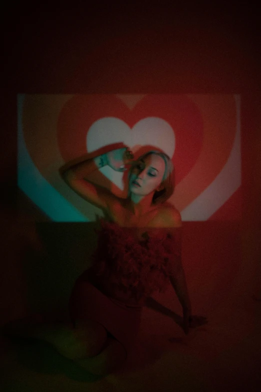 woman posing in front of large screen holding red frisbee