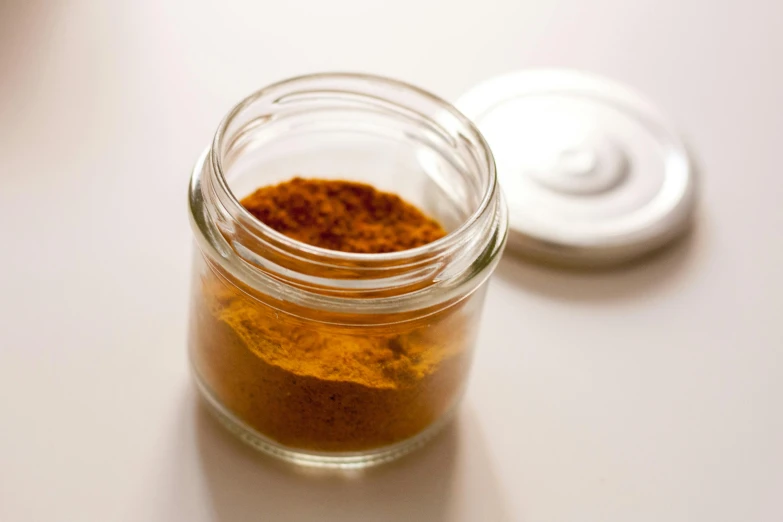 a jar with soing orange sits on top of a table