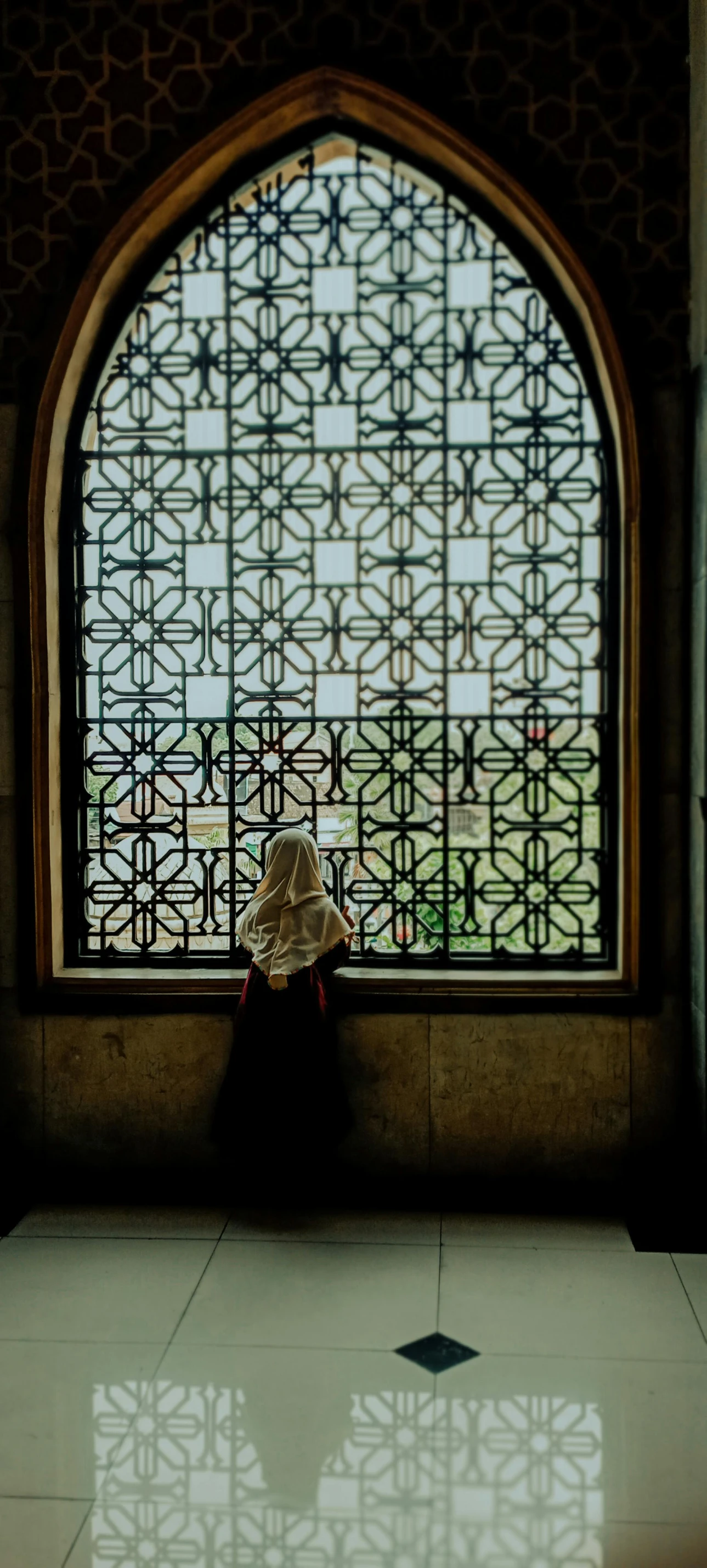 a person is sitting in front of a window with a hat on it