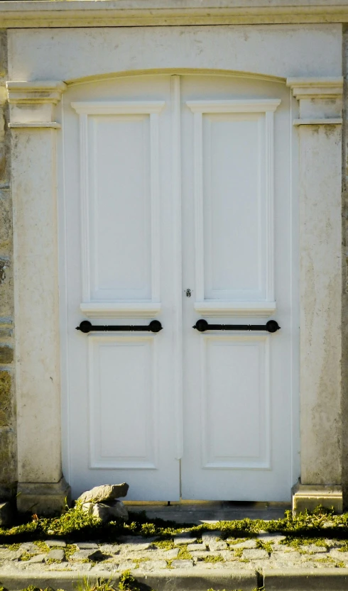 a large white door with two black handles