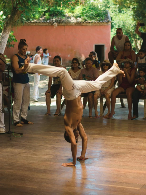 a young man is doing a handstand on the dance floor