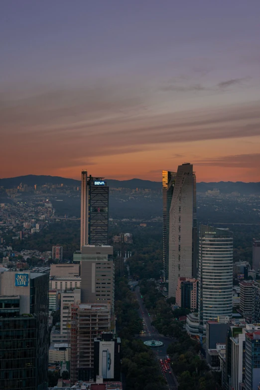 the city skyline as seen at dusk with a big bright screen