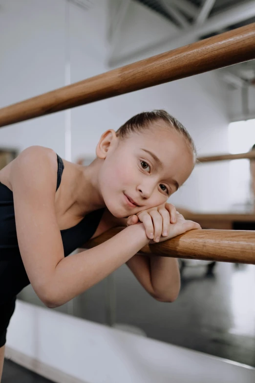 the little girl is leaning against the rail and posing for a po