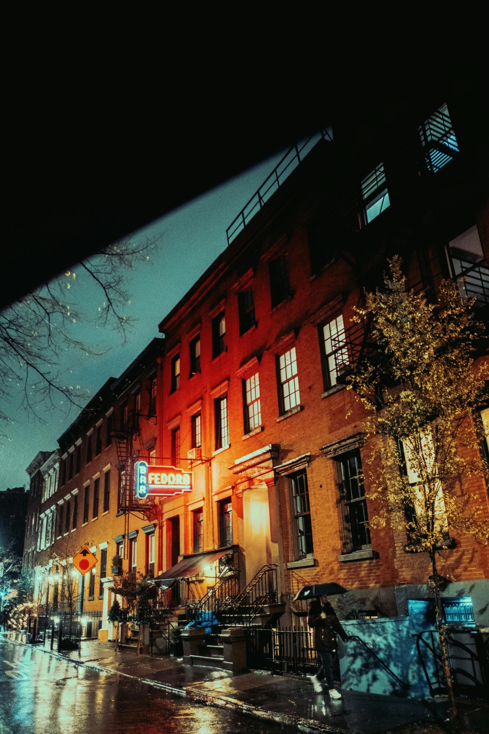 a night view of a very tall building with cars parked outside