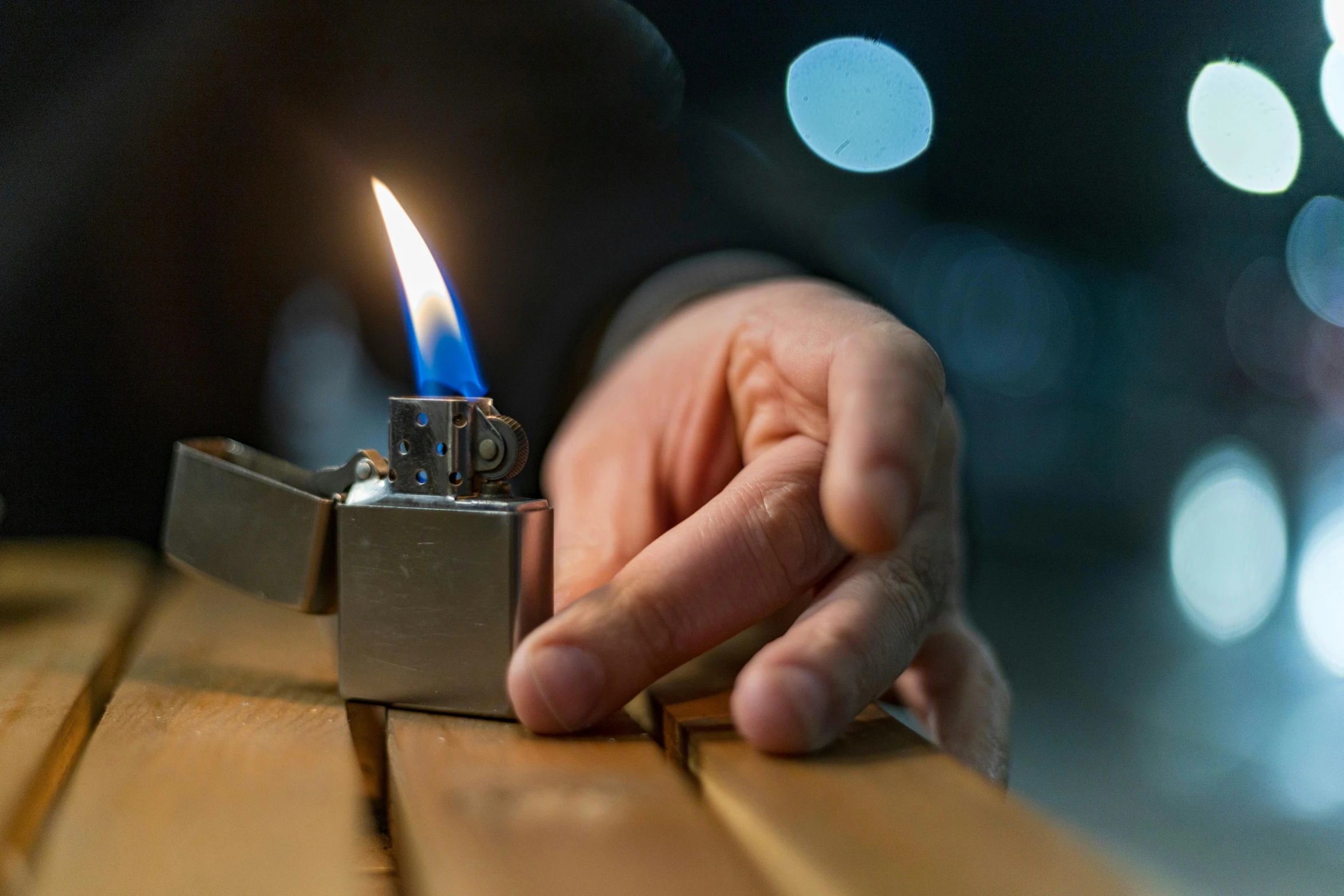 someone holding a lighter in their hand while the lighter is on