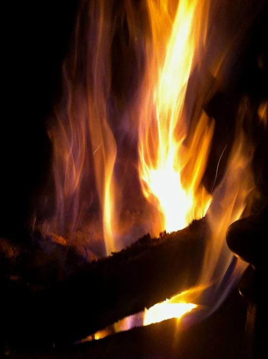 a lit fire with a pile of sticks