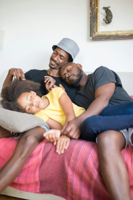 two adults laying on a bed with a young child