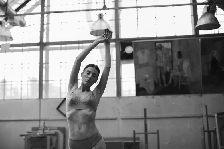 woman wearing underwear balancing on her leg in an industrial setting