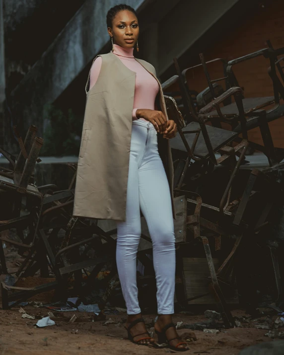 a woman in beige jacket standing by an assortment of chairs