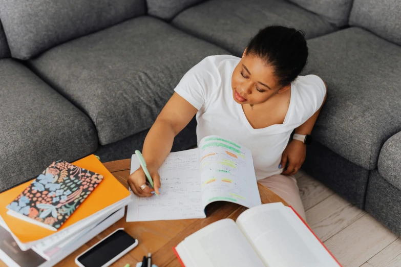 a woman is sitting at a table with some books