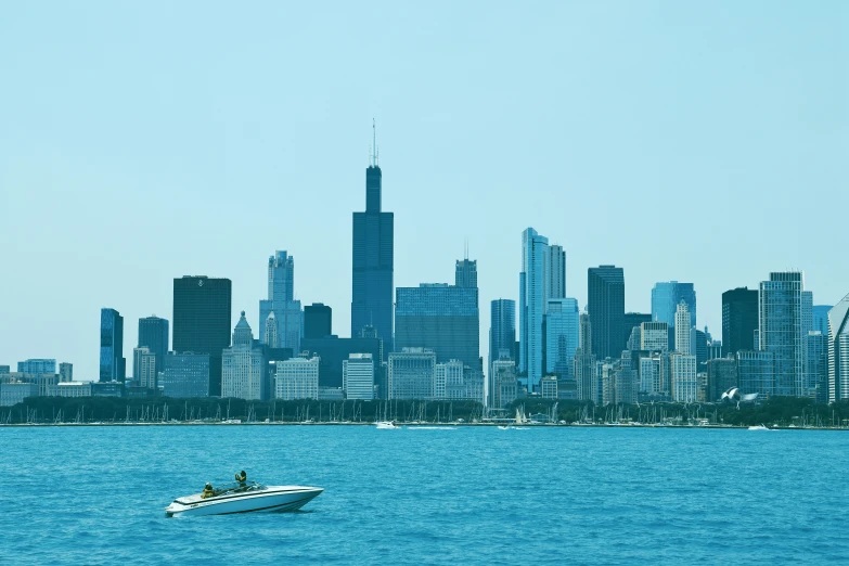 a boat is in the ocean with a city in the background