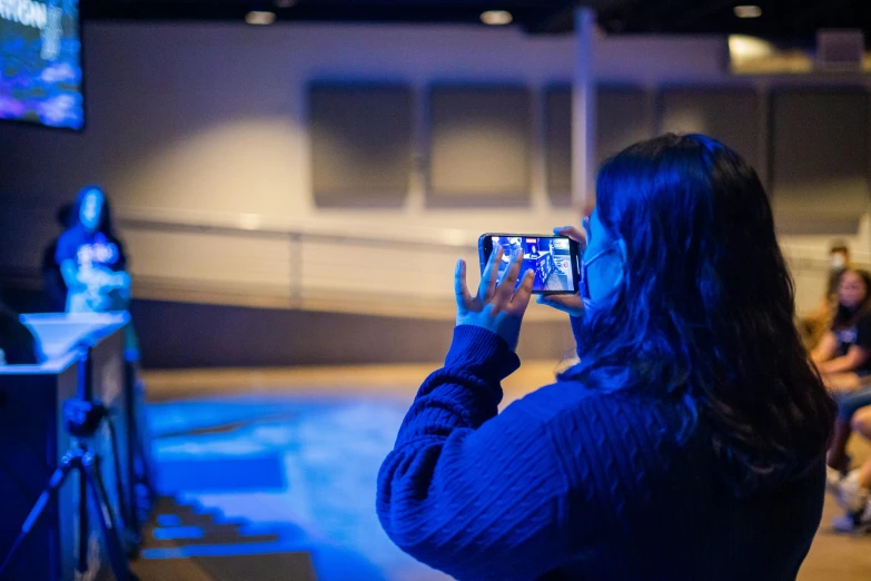 a woman taking a po with her phone at night